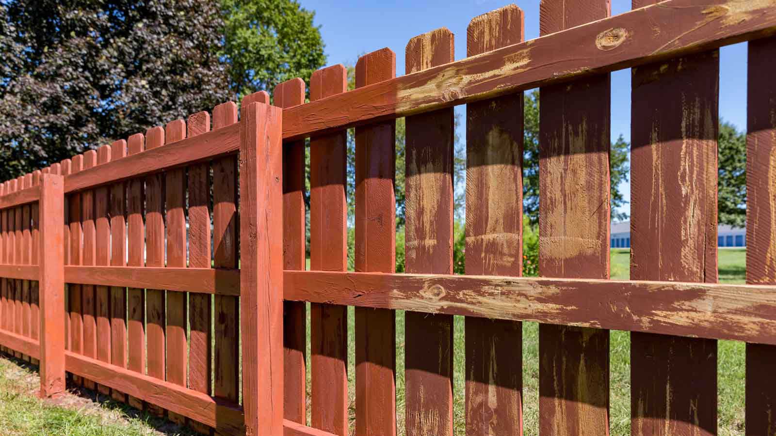 a red fence with trees in the background