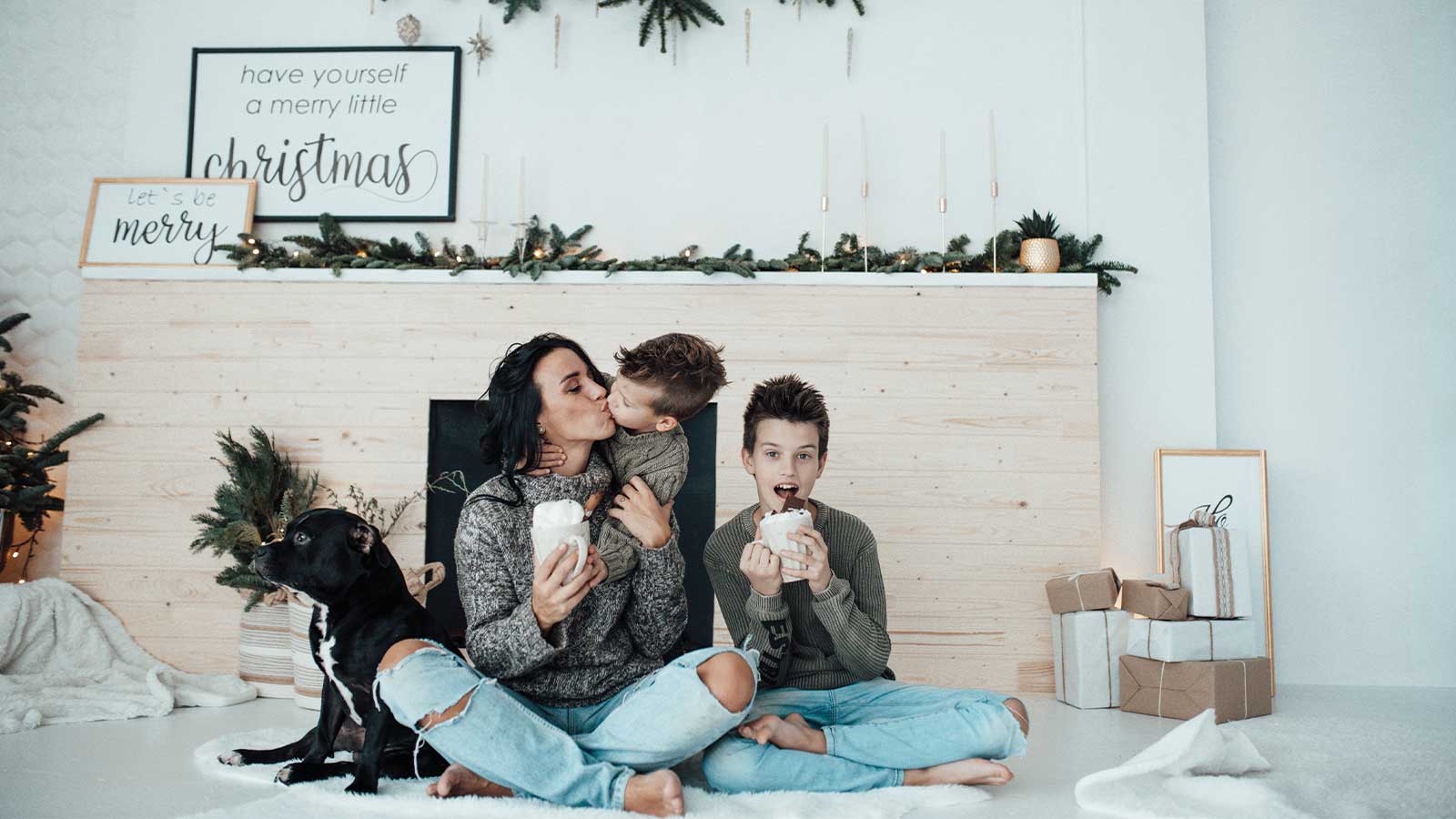 A modern family enjoying hot cocoa in a beautifully decorated room with a Christmas theme, showcasing warm tones for winter. A cozy scene that demonstrates how Roarty Painting can help you transform your home with paint in Maple Ridge.