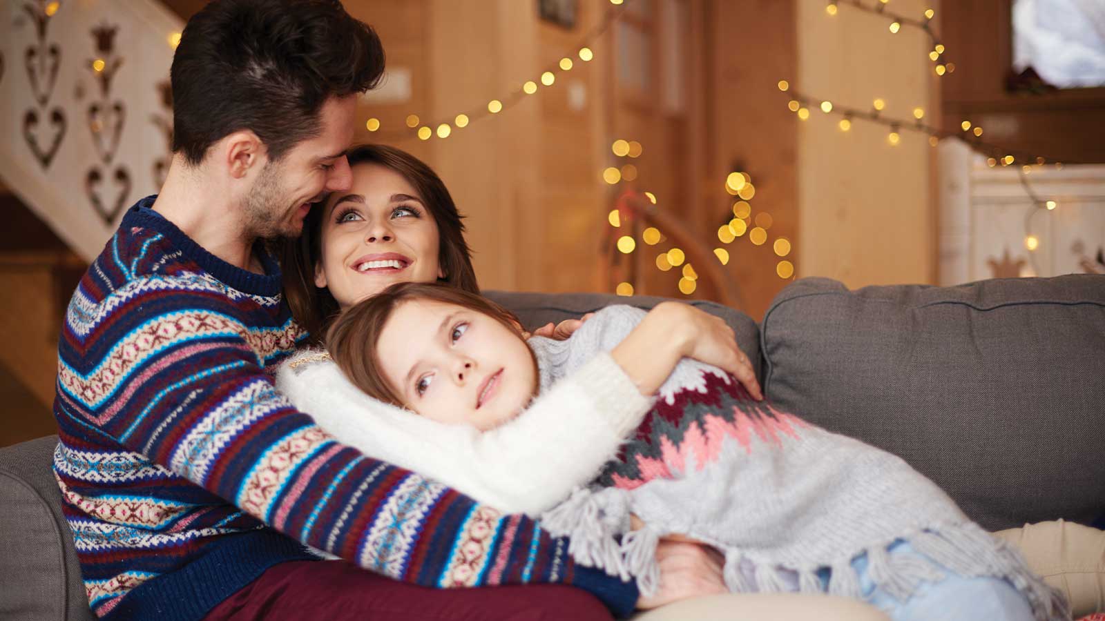 A cozy family moment in a warmly lit living room, featuring festive decor that highlights warm colors for winter. The setting evokes comfort and togetherness, perfect for the seasonal transformation of your home with paint by Roarty Painting, your Maple Ridge painter.