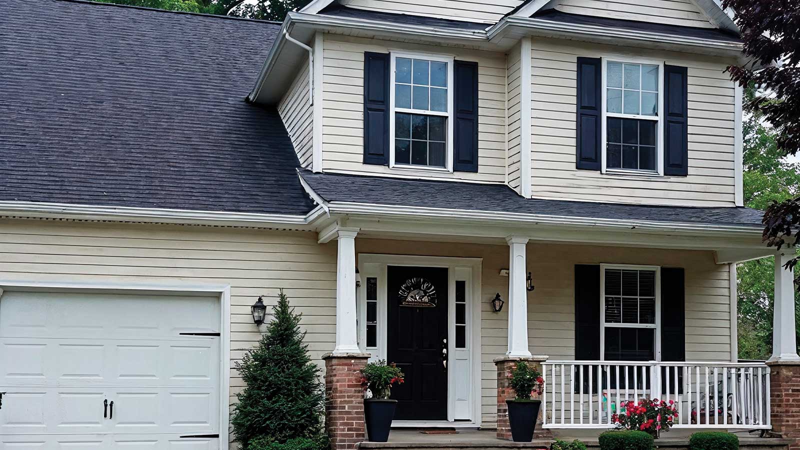 A cream-colored home featuring black shutters and a freshly painted black door demonstrates Roarty Painting’s expert use of the 10 Curb Appeal Tips That Start with a Fresh Coat of Paint to create polished contrast, modern elegance, and improved resale appeal.