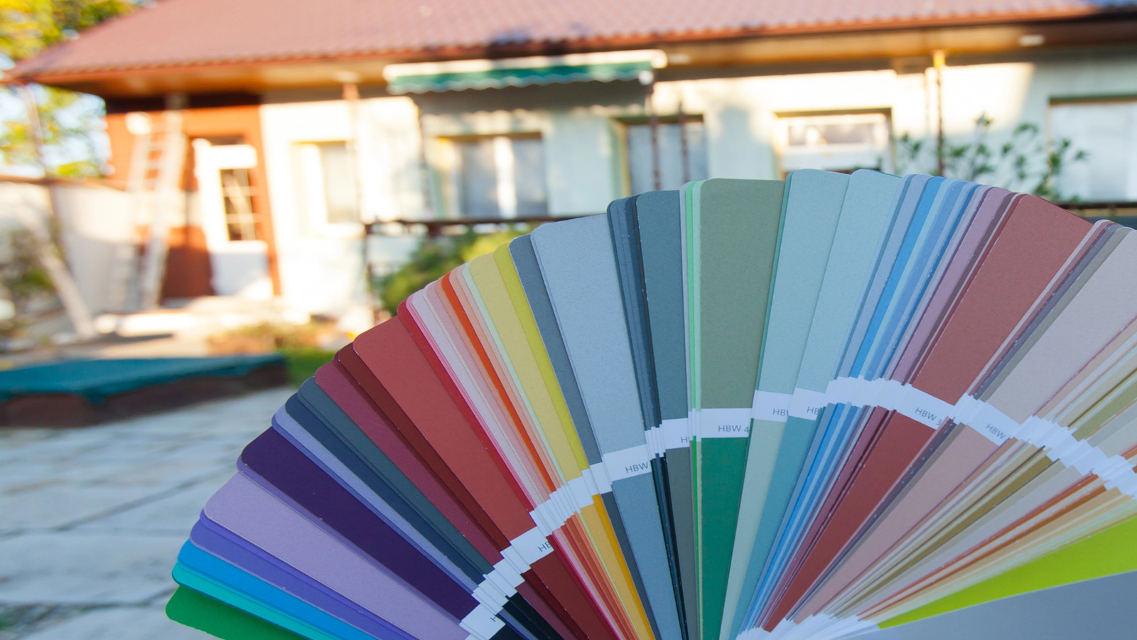 A vibrant fan of paint swatches held in front of a house, showcasing a wide range of color options for exterior paint. Roarty Painting helps homeowners in the Lower Mainland choose the perfect color to enhance curb appeal while ensuring lasting protection and weather resistance.</p>
<p>