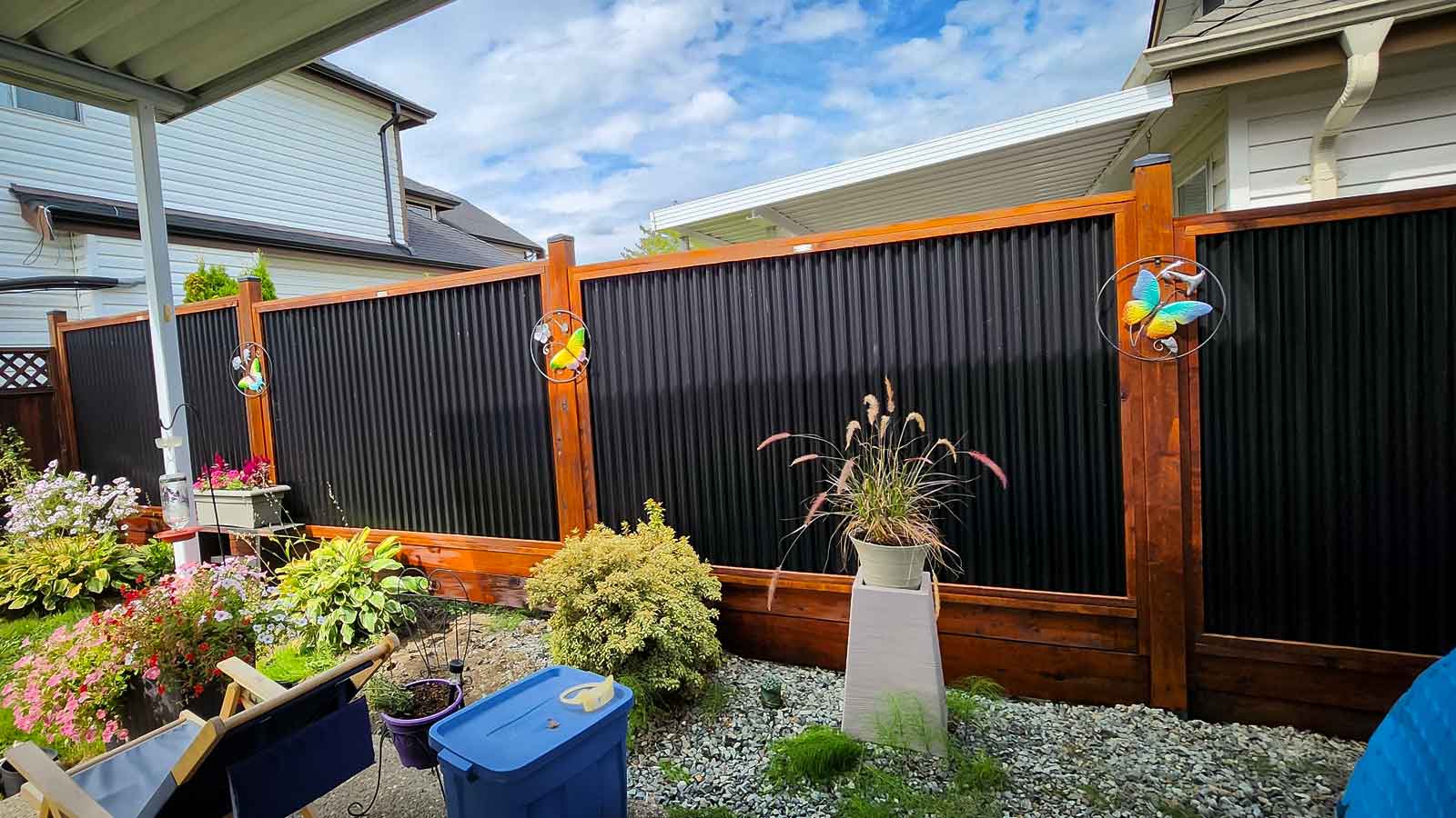 Stained fence in backyard with blue sky in a small suburb.