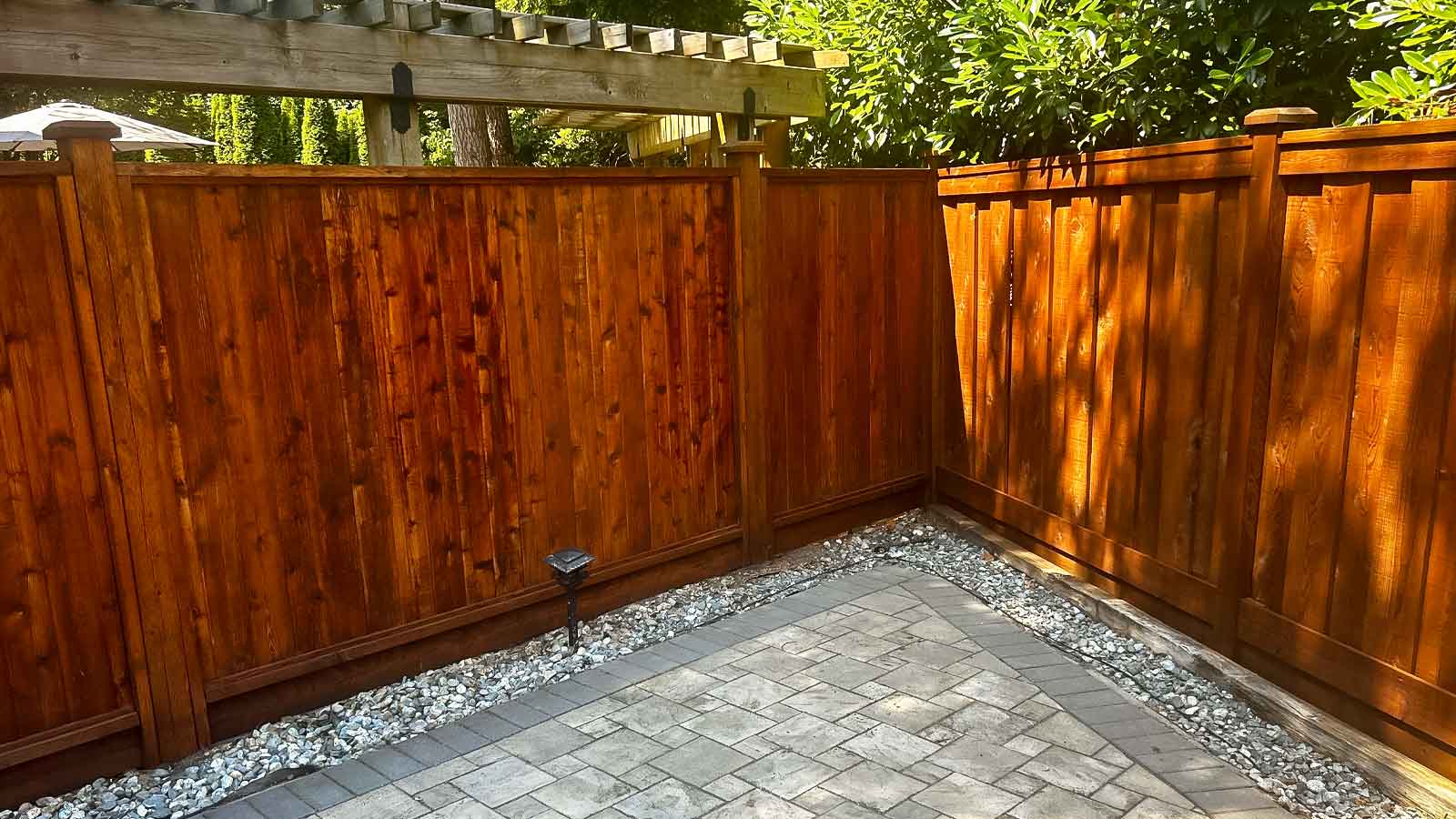 Stained Cedar Fence with pavers in backyard.