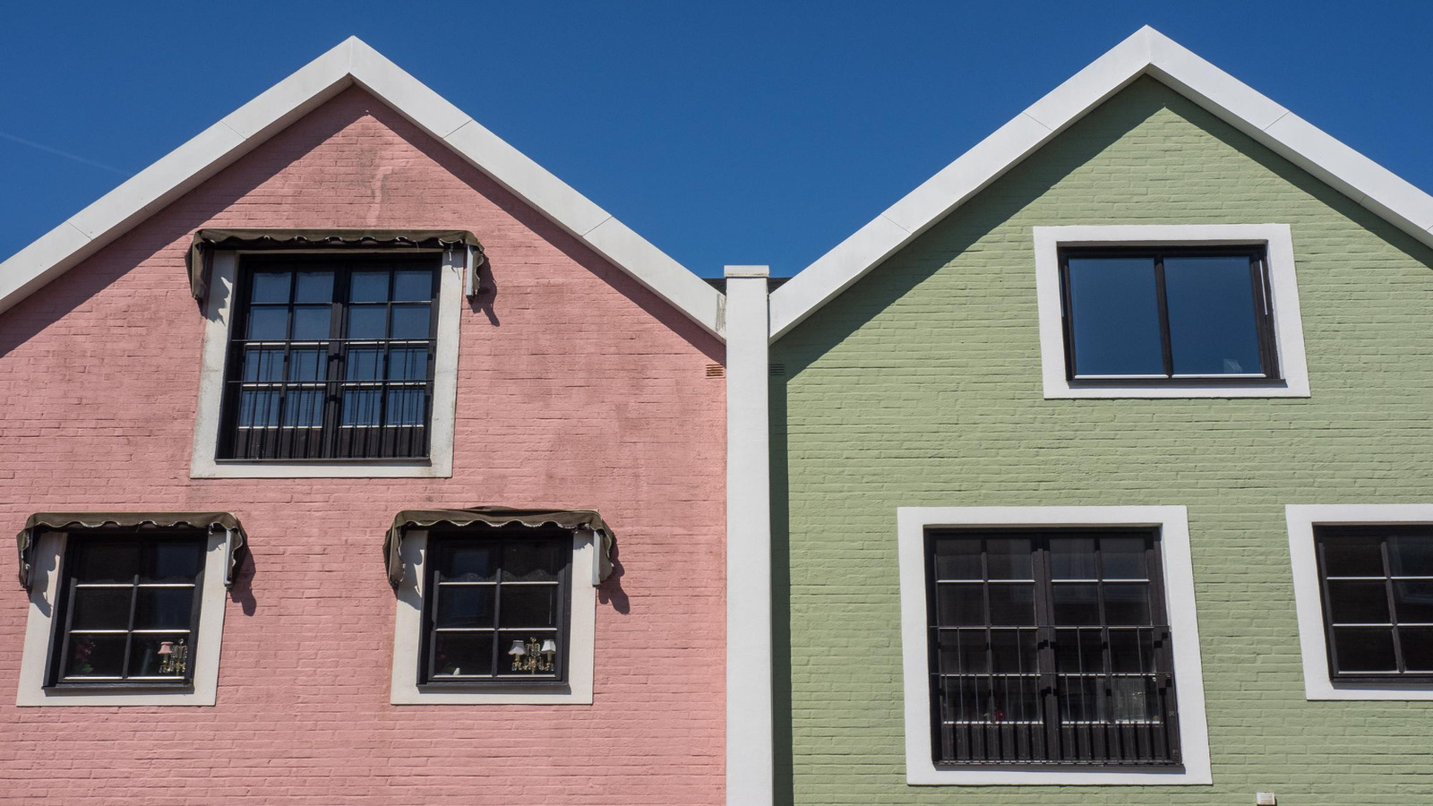 Roarty Painting highlights Warm Tones vs Cool Tones: What Works Best in Vancouver Homes with bold pink and green exteriors under a clear blue sky.